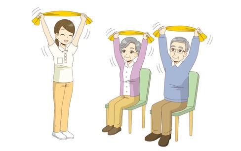椅子に座ったままできるタオルを使った体操を行う高齢者（運動・椅子体操/介護・生活）