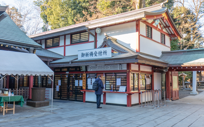 拝殿横にある御祈祷の受付。右に見える通路が参拝者専用無料駐車場へつながっている。