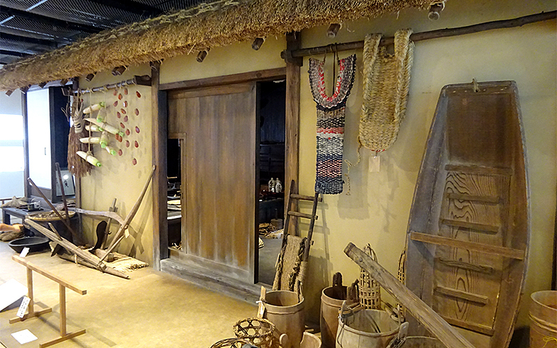 古民家を再現したジオラマや古農具も展示されている。	