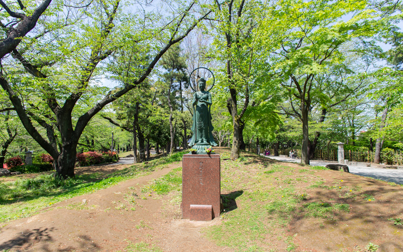 桜並木付近にある「聖観音菩薩像」。1976年北区に寄贈された赤堀信平氏の作品。菩薩像付近は無舗装のため車椅子で近づくことは難しいが、園内通路からその姿を望むことはできる。									