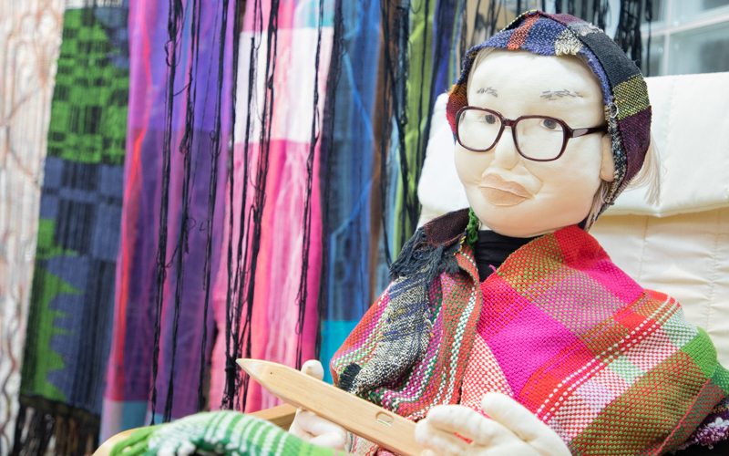 「さをり織り」の創始者である城みさを氏をモデルにした人形が飾られている。
