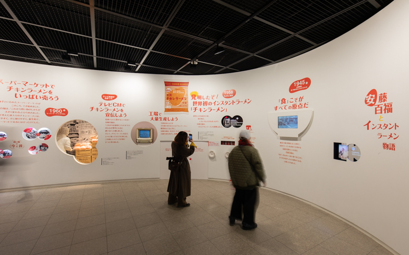 ミュージアム壁面に展示されている「インスタントラーメン物語」には、「チキンラーメン」と「カップヌードル」の誕生秘話が綴られている。
